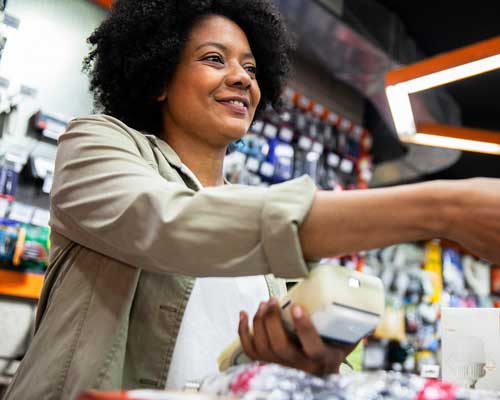 woman checking a customer out in a convenience store | convenience store pos